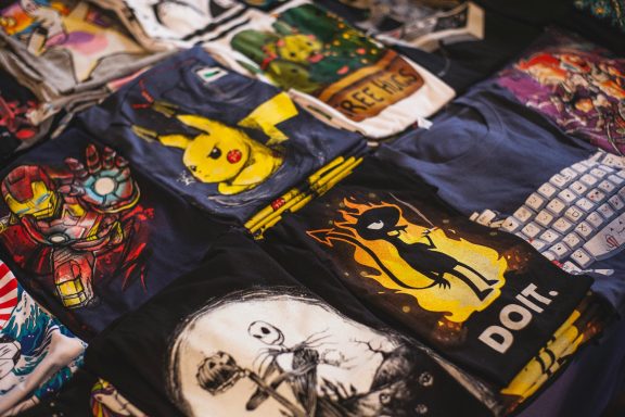 Variada colección de camisetas con diseños de personajes y arte pop.